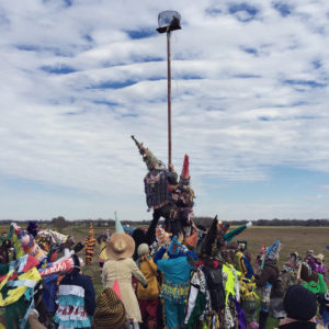 Revelers climb greases pole to reach chicken - photo by Patrick Lorenz